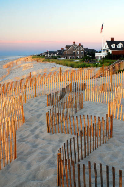 sunset glow illuminating American flag on beach fence