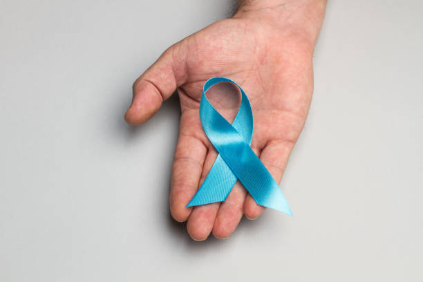 istock A blue ribbon on a man´s hand 1186074896