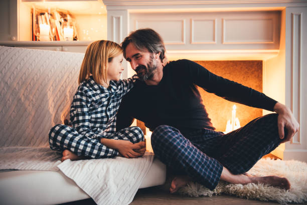istock Father and son sitting together in front of fireplace 1186076354