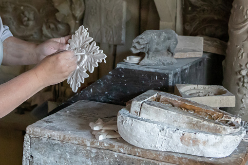 Crafts person preparing plaster masonry moulds in a workshop