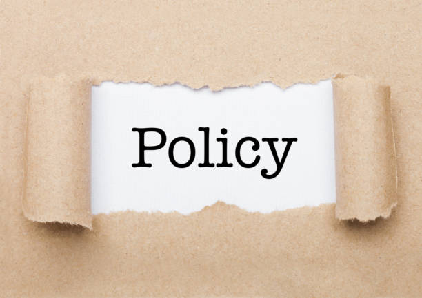 istock Policy concept text appearing behind brown paper 1186083764