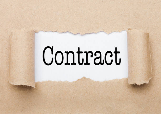 istock Contract text appearing behind torn brown paper 1186084916