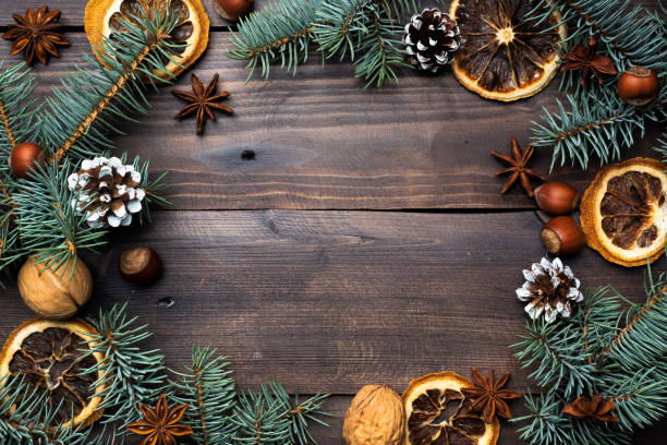 istock Frame of Christmas tree cones oranges nuts on dark wooden background. Copy space. Flat lay. 1186086277