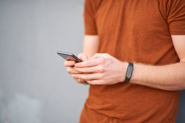 istock Young man using smartphone near a sloppy painted grey urban wall. 1186086769