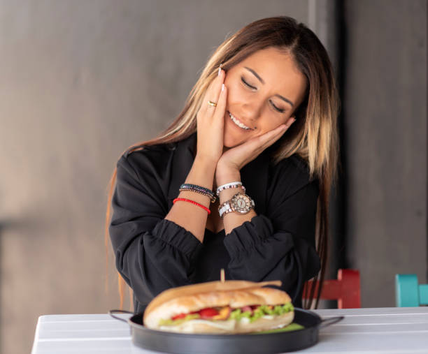 istock Cheerful woman eating a sandwich 1186089104
