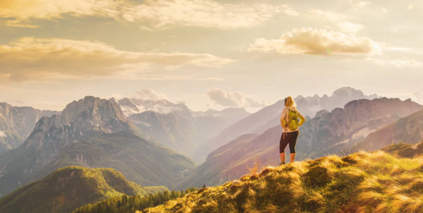 istock Rear view of a single blond female hiker with a backpack standing on a rock formatio 1186089501