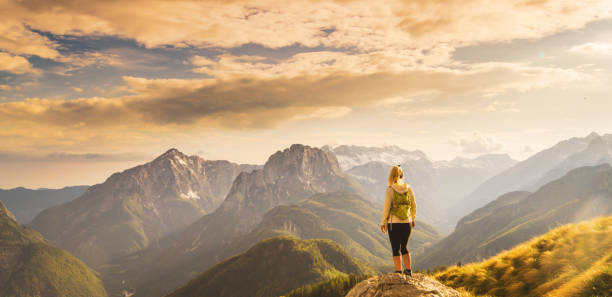 istock Rear view of a single blond female hiker with a backpack standing on a rock formatio 1186089530