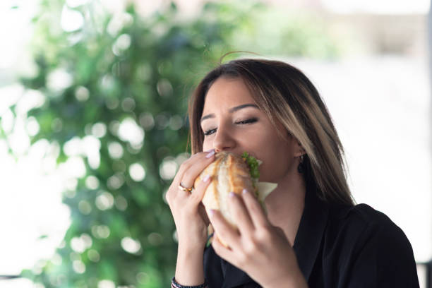 istock Cheerful woman eating a sandwich 1186089547