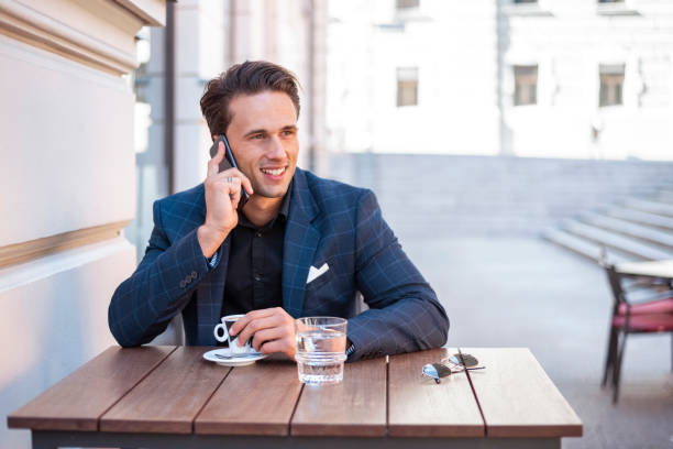 istock Young man talking on cell phone in outdoors cafe 1186090035