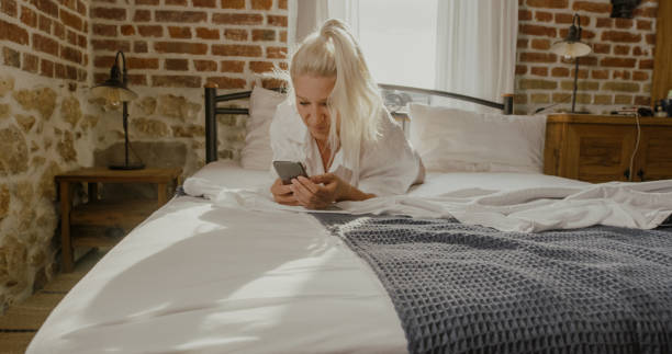 istock Young woman using smart phone in her bed 1186092498