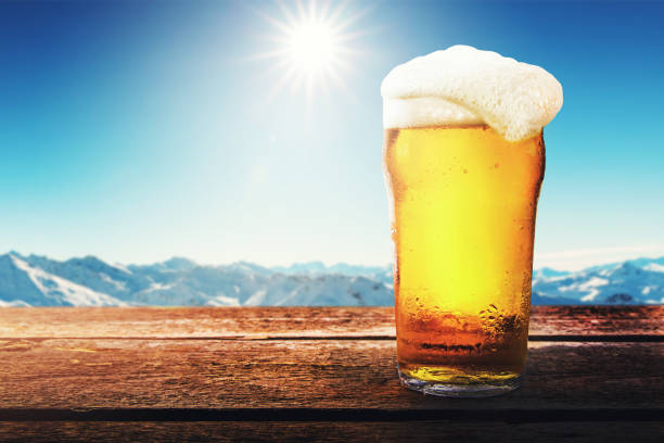 スキーリゾートで日当たりの良い冬の山の風景とテーブルの上に冷たいビールグラス - アプレススキー。スペースのコピー - apres ski 写真 ストックフォトと画像
