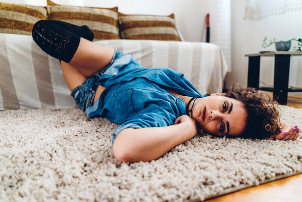 istock Seductive woman lying on carpet 1186093171