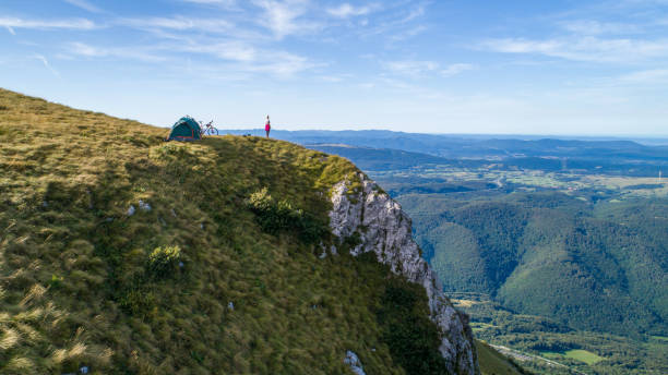 istock Distant view of woman camping in mountains. 1186093330