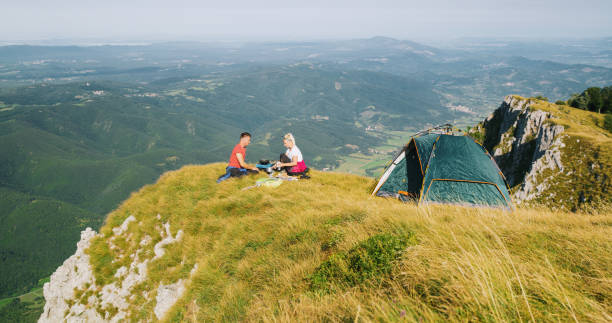 istock Couple cooking while camping in mountains, Nanos 1186093444