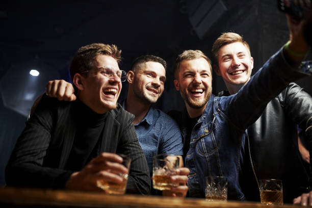 istock Taking a photo. Friends resting in the pub with alcohol in hands. Having conversation 1186098749