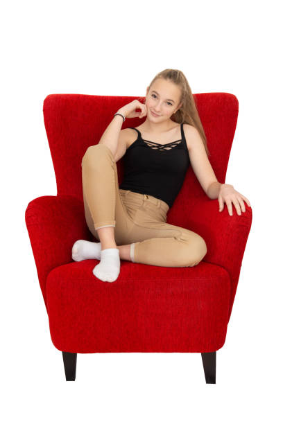Woman sitting on white box in red light.
