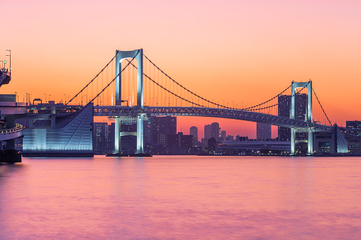 Photo of the Rainbow Bridge in Tokyo bay at the purple sunset time.