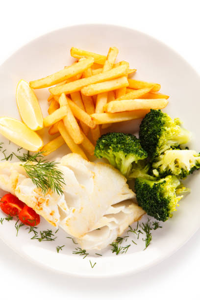 Fish dish - cod with French fries and vegetables on white background