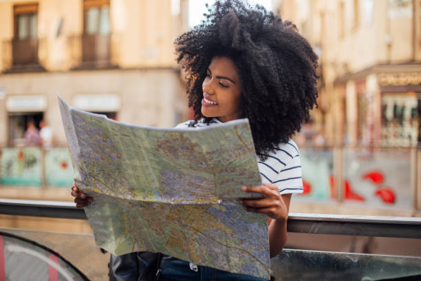 istock Cheerful female tourist holding a map 1186101709