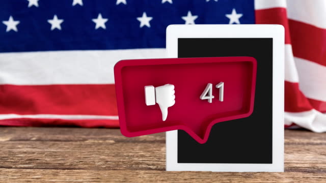 Thumbs down icon and an American flag behind a tablet