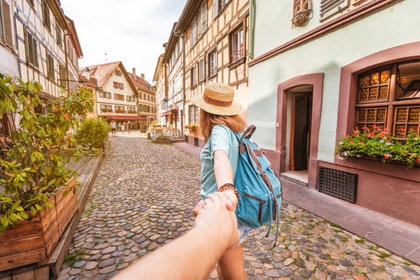 touristin begrüßt ihren freund, um ihr auf der stadtstraße in europa zu folgen - journey elegance people traveling architecture stock-fotos und bilder