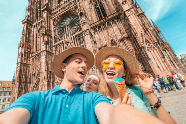 grupo multiétnico de amigos que têm o divertimento e que provao o gelado no fundo da catedral de notre dame de strasbourg - strasbourg cathedral - fotografias e filmes do acervo