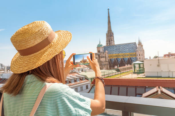 Young female asian tourist taking photo with Saint Stephen cathedral while travelling in Vienna Young female asian tourist taking photo with Saint Stephen cathedral while travelling in Vienna st. stephens cathedral vienna photos stock pictures, royalty-free photos & images