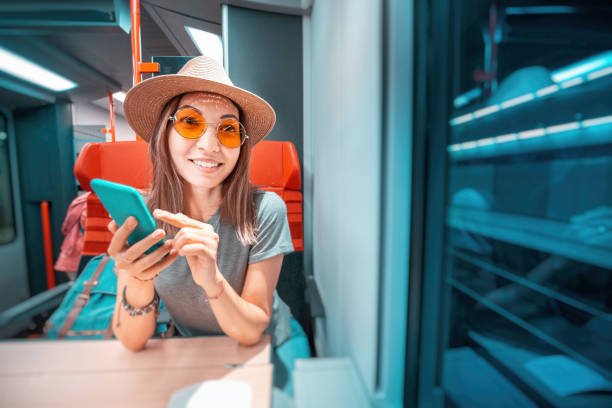 istock Asian happy woman using smartphone inside far distant train. Railroad Travelling and internet connection concept 1186106532
