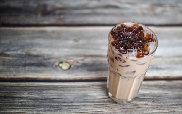 나무 테이블에 갈색 설탕 젤리가있는 아이스 밀크 티 한 잔 - chocolate nobody water tea 뉴스 사진 이미지