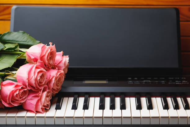 istock pink roses bouquet on electric piano keys 1186107672