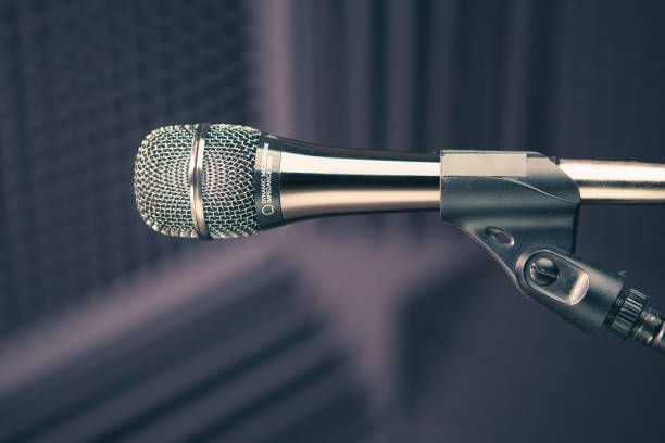 istock microphone on stand, brown background with acoustic foam wall in studio 1186108721