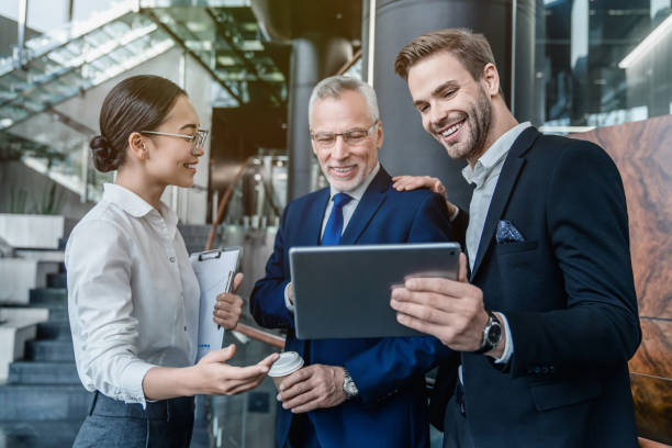 istock Group of coworkers in suits working together on digital tablet 1186109609