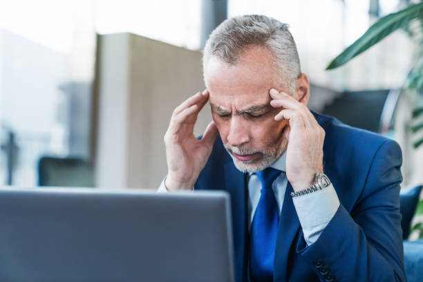 istock Senior businessman feeling headache while doing distance work in coffee shop 1186109869