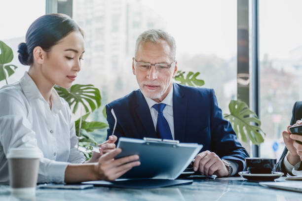 business people working on business contract papers at office - computer two people asian ethnicity women imagens e fotografias de stock