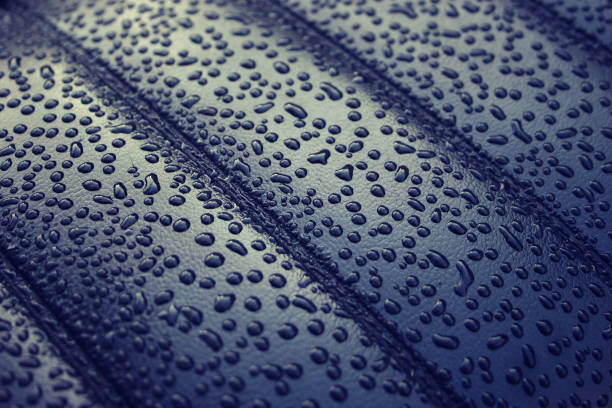 gocce di pioggia d'acqua su sfondo pelle scura - car leather hide seat foto e immagini stock