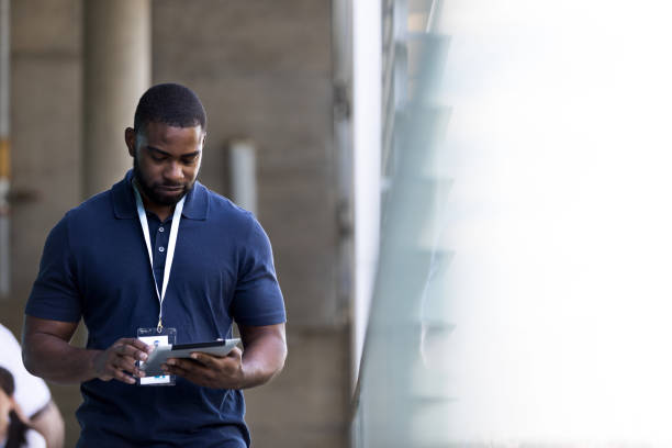 Businessman uses digital table while walking outside the office building