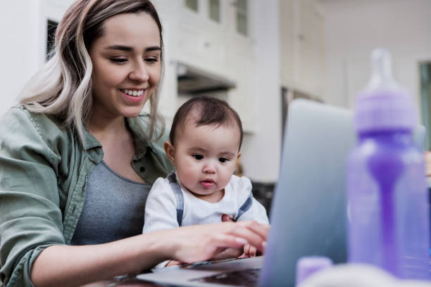 istock Mom holds baby while working from home 1186116348