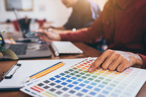 istock Graphic Design Colleagues Choosing Color Swatch For Website Design at Co-working Space Room. 1186121364