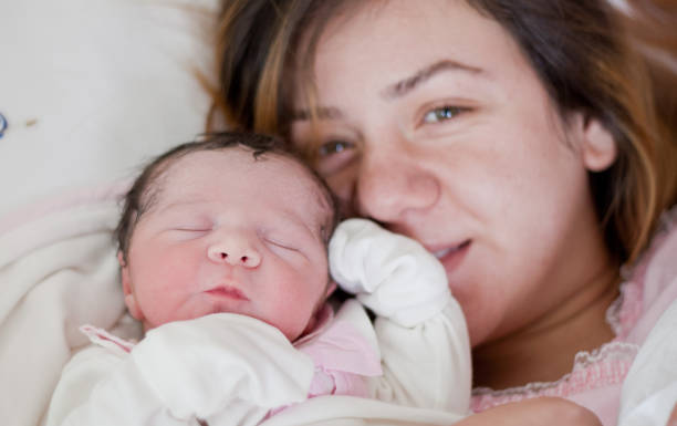 новый ребенок с матерью на кровати - new childbirth new life love стоковые фото и изображения