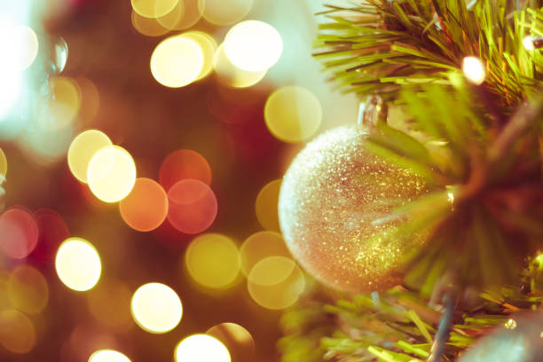 istock Decorated Christmas tree on blurred varicolored new year's background 1186128468