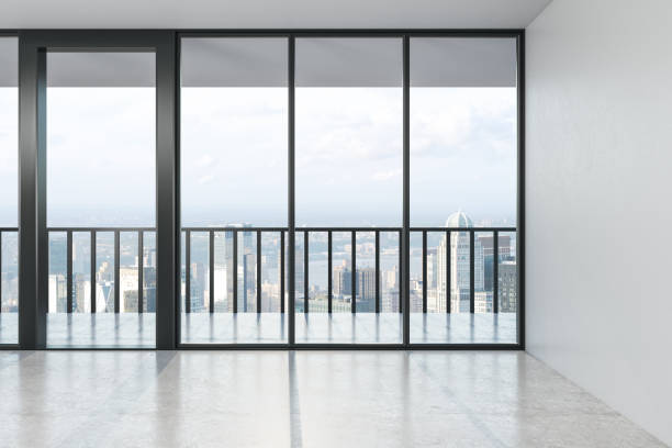 istock Empty modern spacious hall with concrete floor, big window with city view in the afternoon. 1186129206