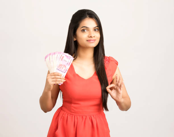 istock Happy young woman holding Indian 2000 rupee notes 1186129374