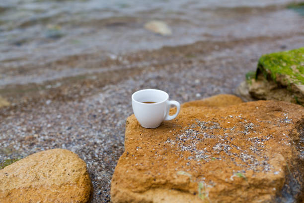 istock White mug, mock up, empty space for artwork, text, standing on wood plank, turquoise sea, clear blue sky, horizon, sunlight, nature 1186130054