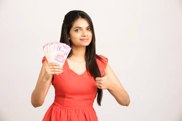 Happy young woman holding Indian 2000 rupee notes