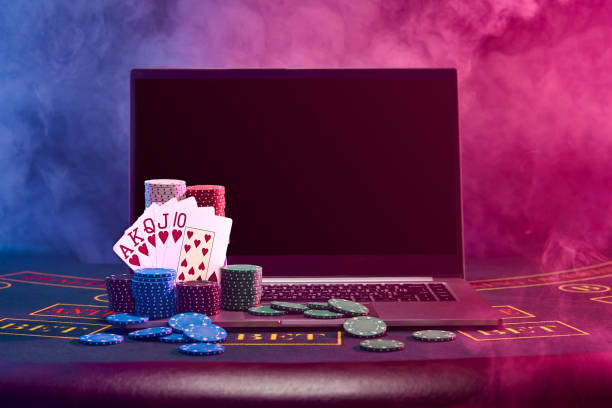 stosy żetonów i karty do gry na laptopie stojące na niebieskiej okładce stołu. czarny, tło dymu. hazard, poker, koncepcja kasyna. zbliżenie - casino black and white gambling chip gambling zdjęcia i obrazy z banku zdjęć