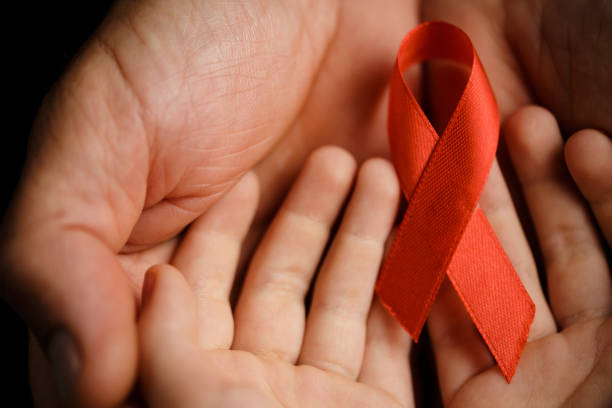 istock child with AID red ribbon on a dark background 1186130758