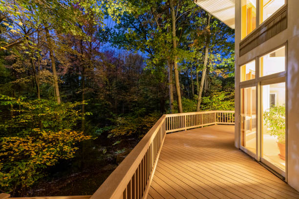 Deck on Home in Woods at Night Large composite deck on a luxury home in the woods photographed at night.  Concepts could include architecture, design, outdoor living, luxury living, nature, others. decking stock pictures, royalty-free photos & images