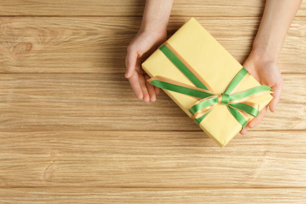 istock gift box in the hands on a wooden background top view 1186132735