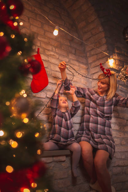 istock Mother and daughter decorating Christmas tree 1186132784