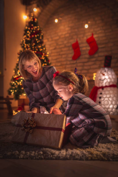 istock Mother and daughter opening Christmas presents 1186133543